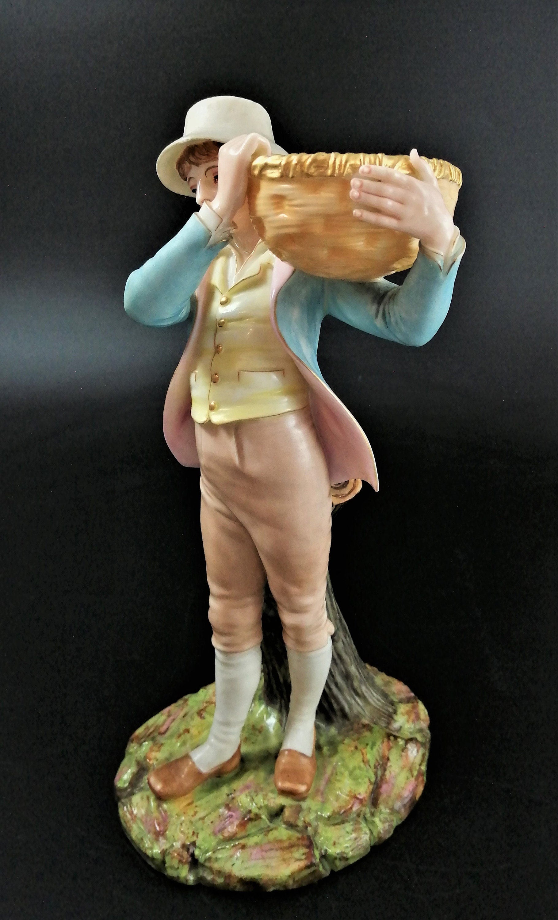 Antique Royal Worcester figural spill holder,of boy carrying basket,James Hadley