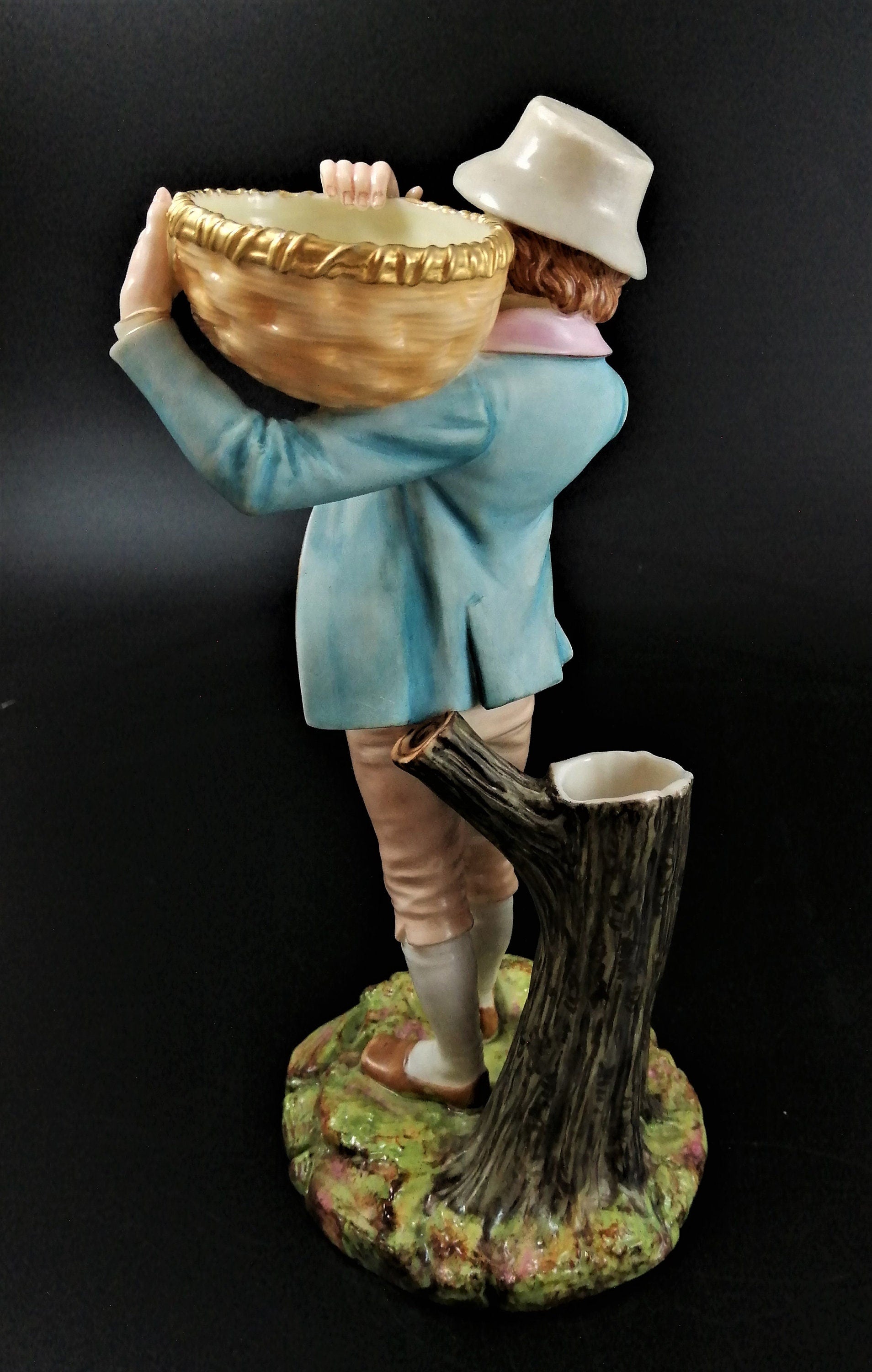 Antique Royal Worcester figural spill holder,of boy carrying basket,James Hadley