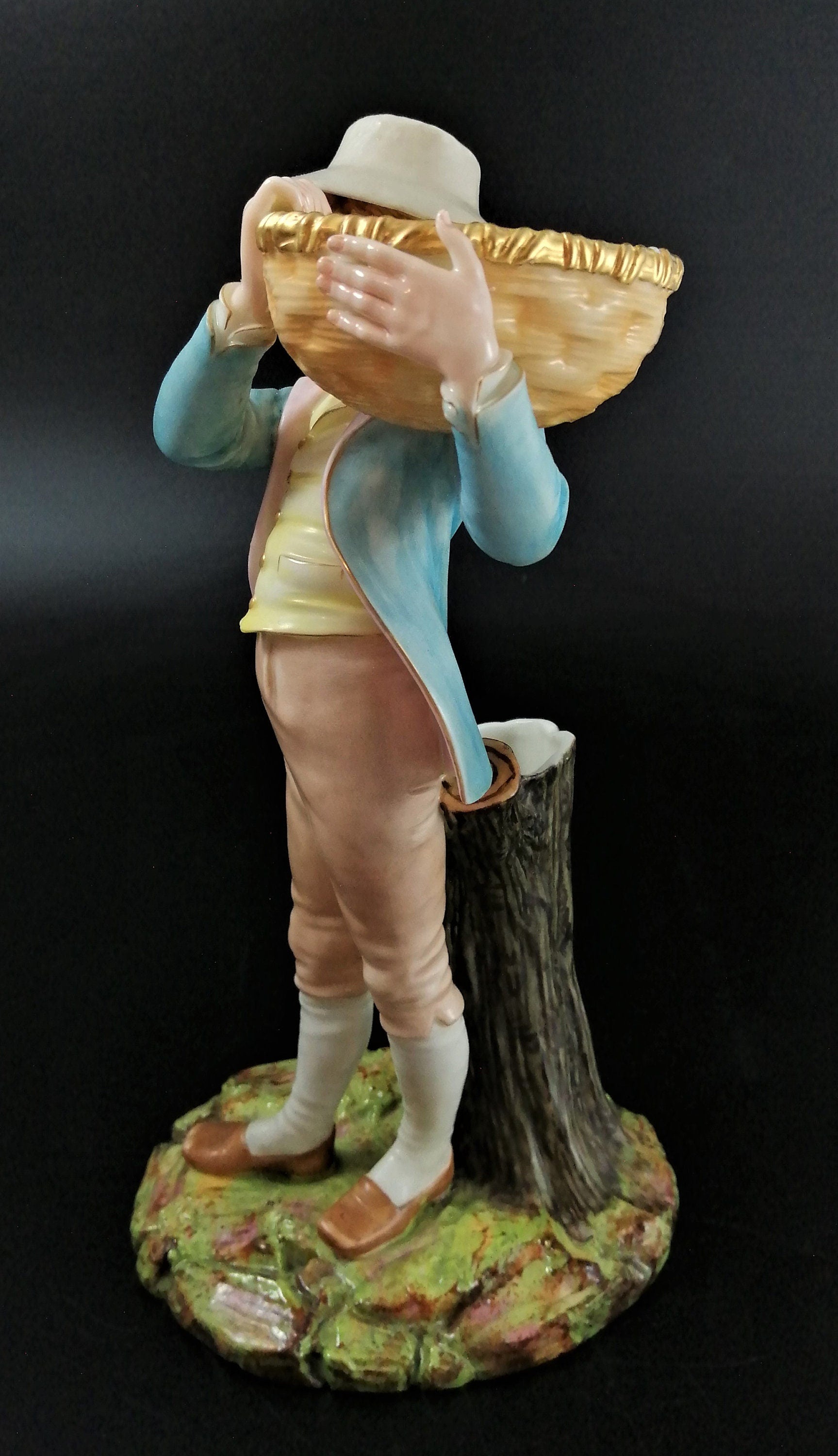 Antique Royal Worcester figural spill holder,of boy carrying basket,James Hadley