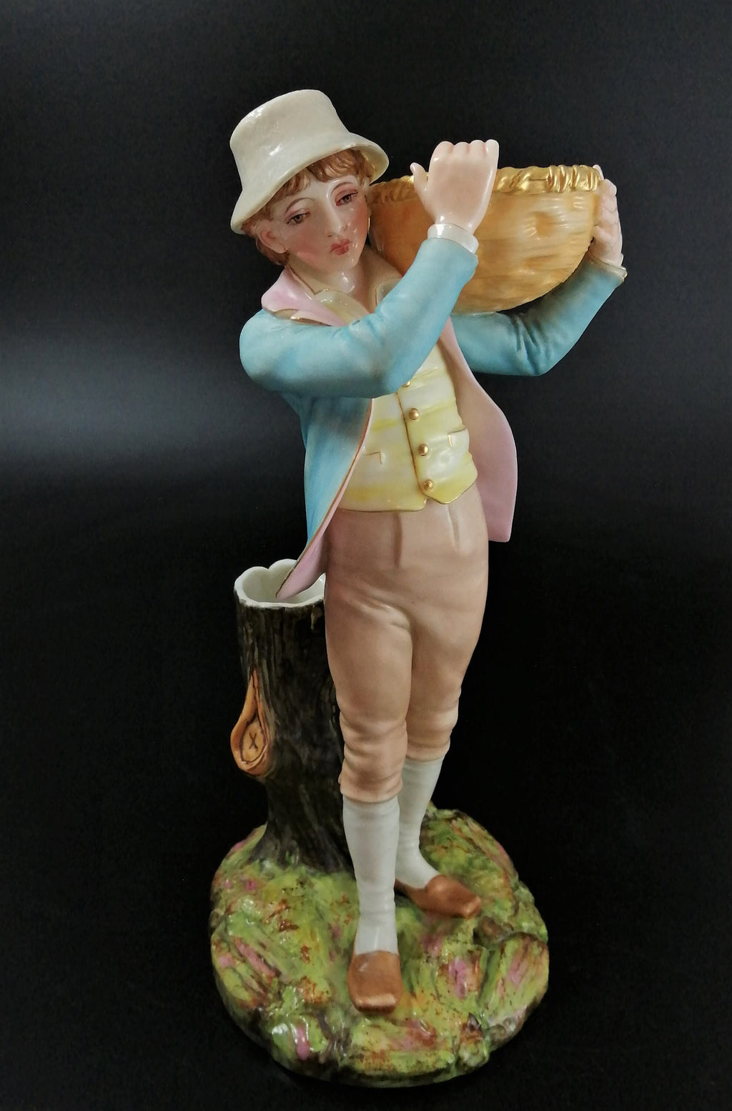 Antique Royal Worcester figural spill holder,of boy carrying basket,James Hadley