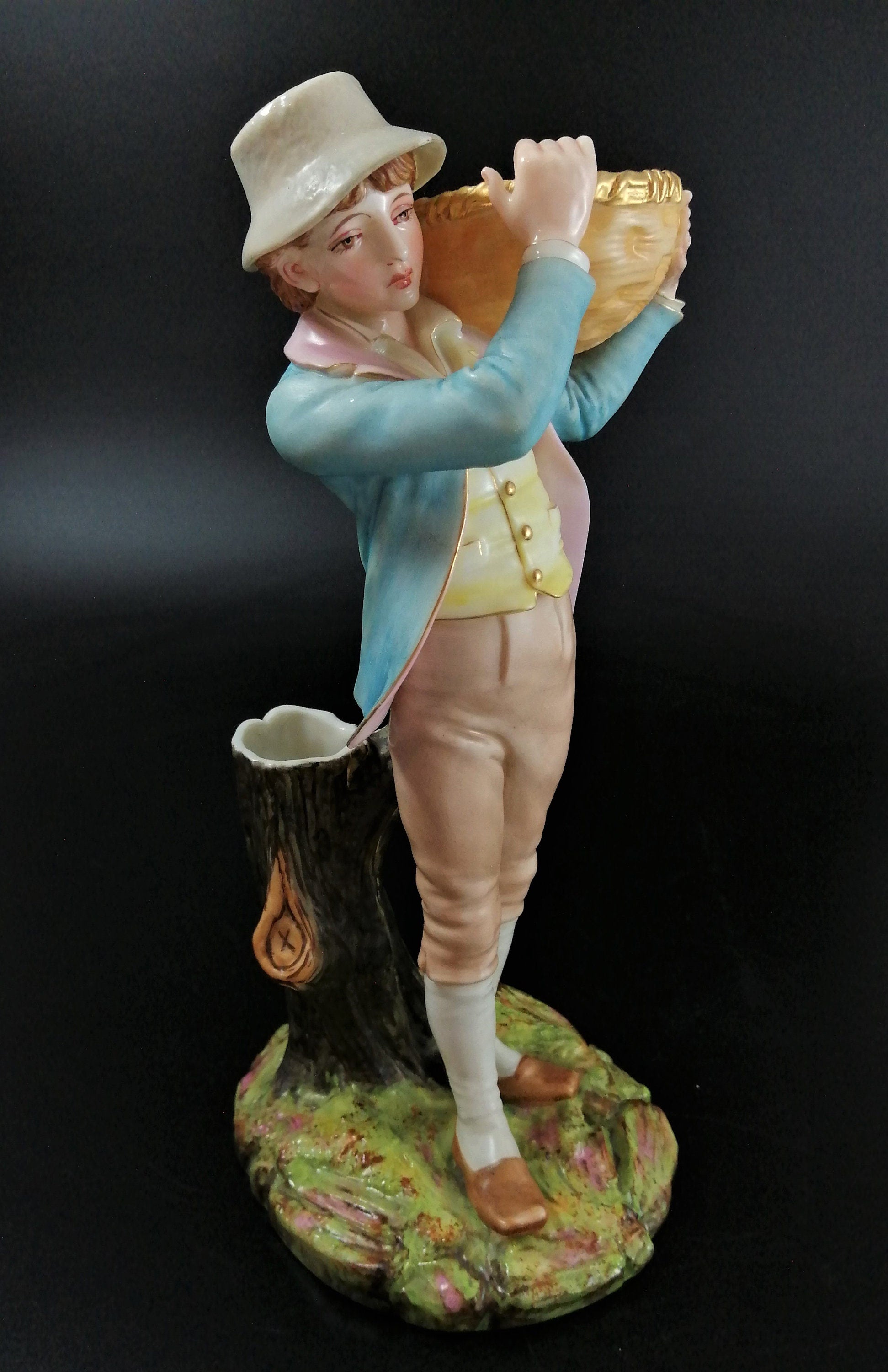 Antique Royal Worcester figural spill holder,of boy carrying basket,James Hadley