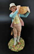 Antique Royal Worcester figural spill holder,of boy carrying basket,James Hadley