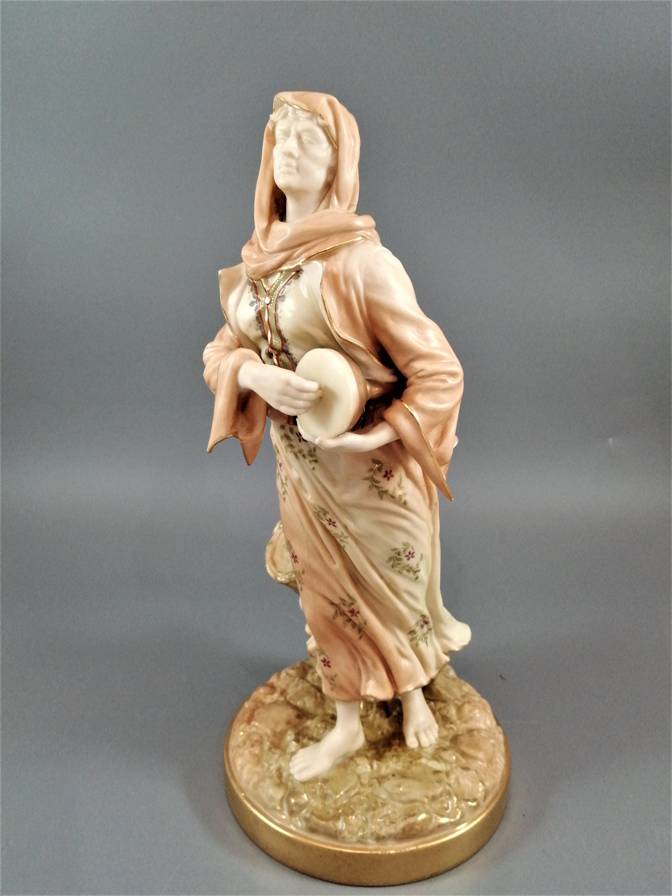 A rare Royal Worcester figurine titled "Musician," depicting a lady with a drum , 1898.