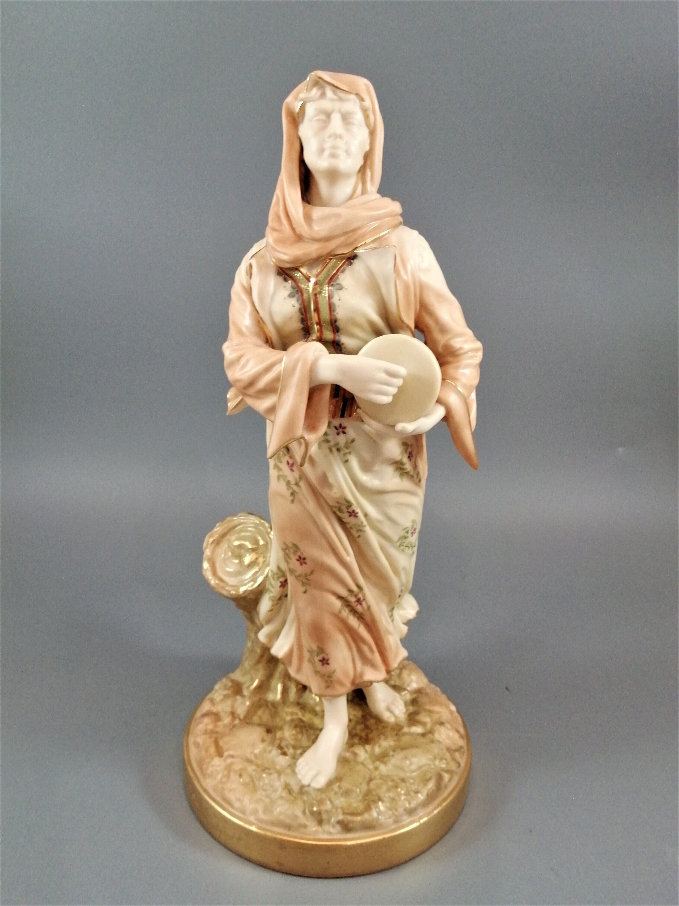 A rare Royal Worcester figurine titled "Musician," depicting a lady with a drum , 1898.