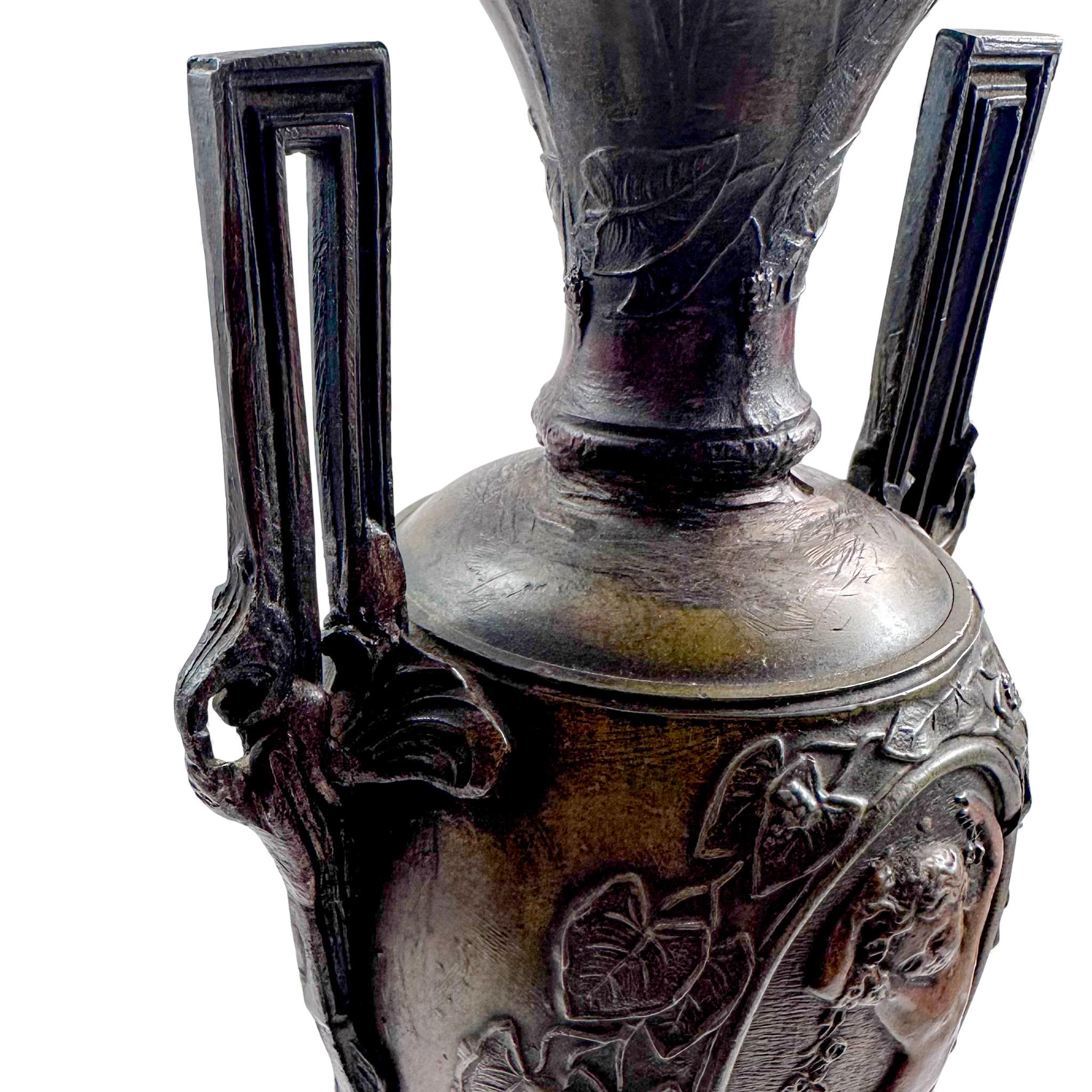 Pair of antique French Amphora vases, spelter with cherub relief, 19th century