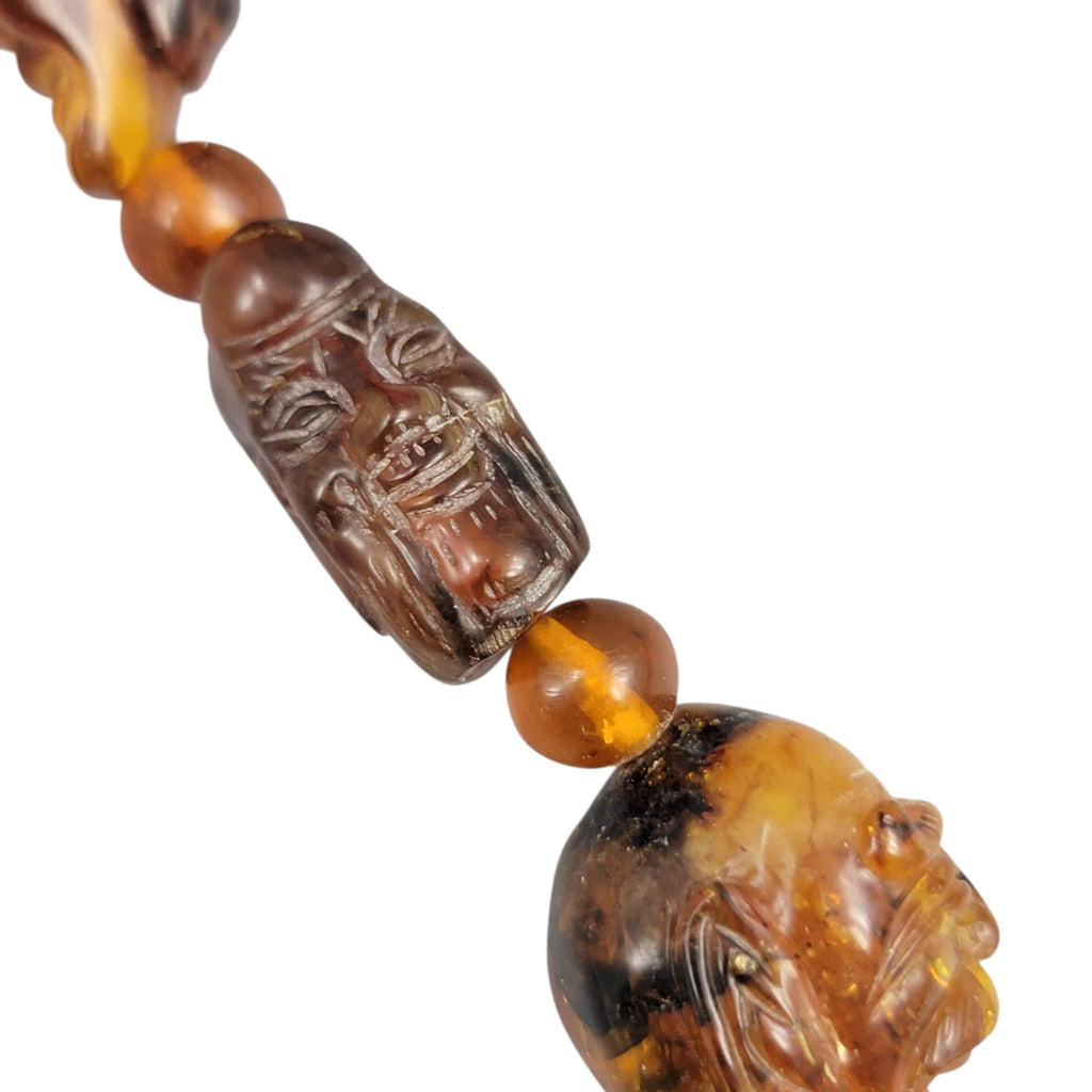 Chinese carved amber necklace with luohan heads and figural pendant, c. 1870