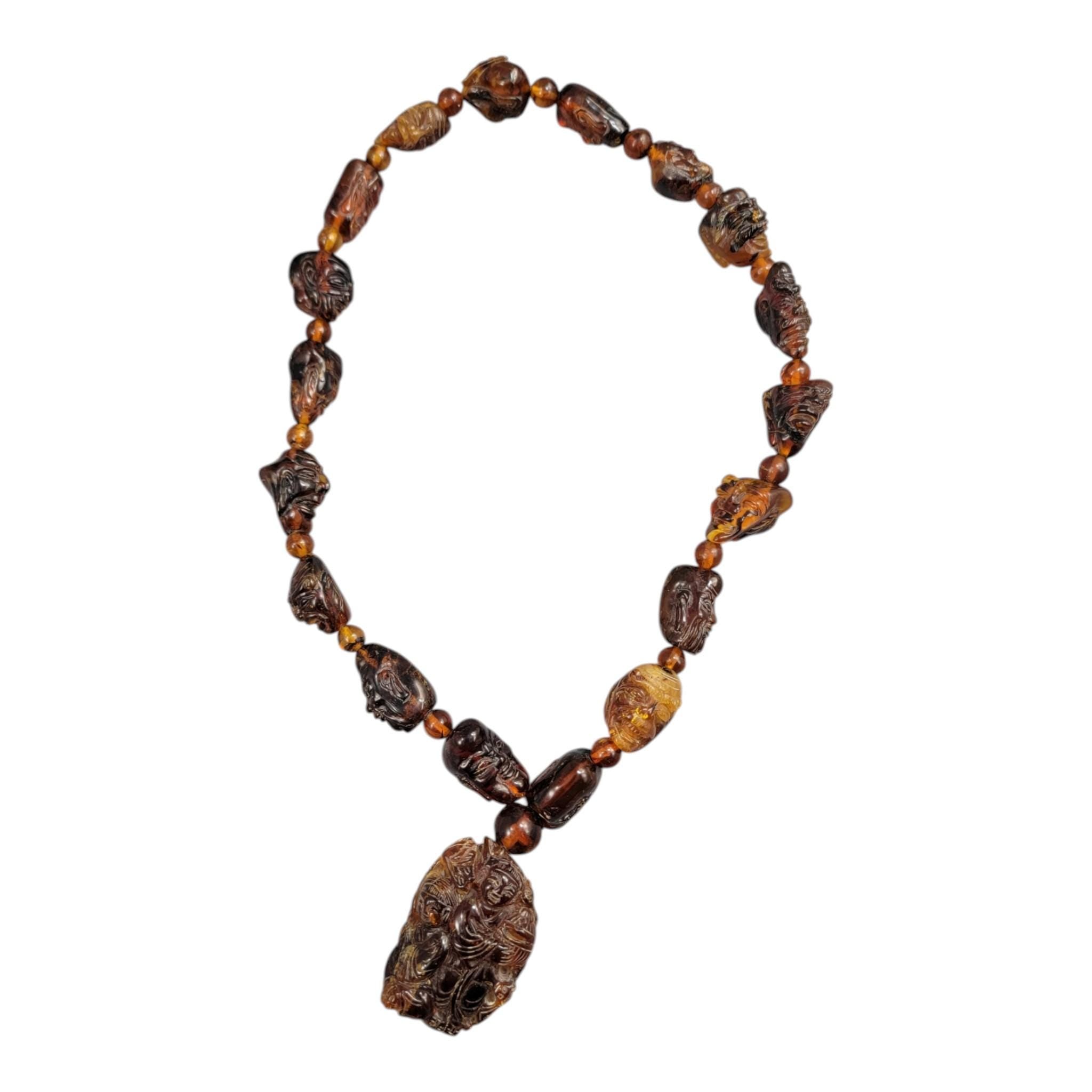 Chinese carved amber necklace with luohan heads and figural pendant, c. 1870