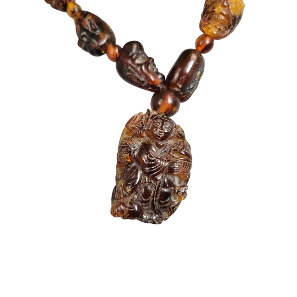 Chinese carved amber necklace with luohan heads and figural pendant, c. 1870