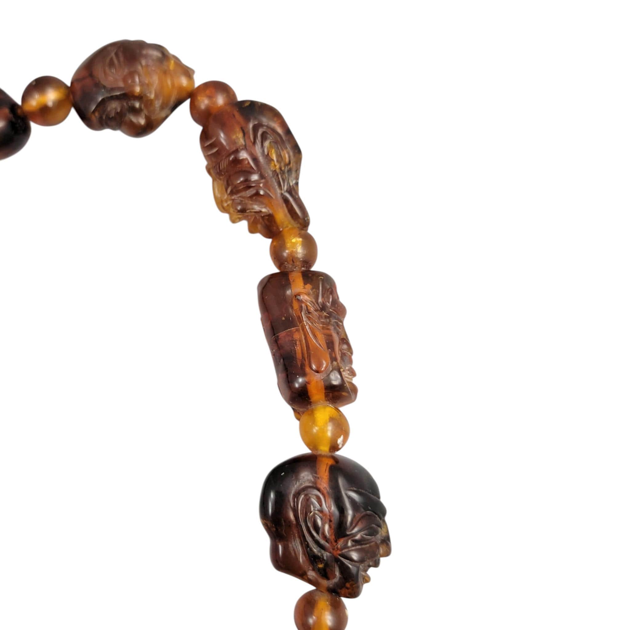Chinese carved amber necklace with luohan heads and figural pendant, c. 1870