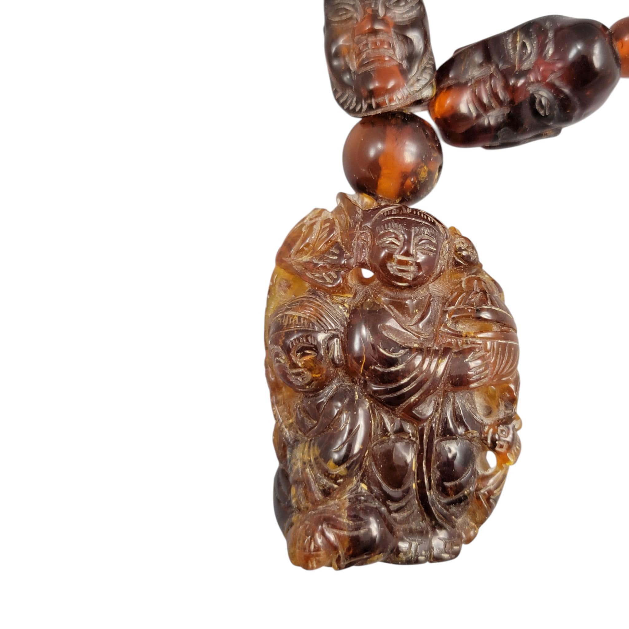 Chinese carved amber necklace with luohan heads and figural pendant, c. 1870